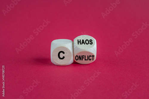 Obraz na płótnie Conflict and chaos symbol. Wooden cubes form the expression from Conflict to Chaos. Beautiful red background. Business Conflict and Chaos concept. w salonie