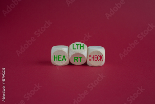Obraz na płótnie Wooden cubes with the expression 'heart check' and 'health check'. Beautiful pink background. Medical and business concept. w salonie