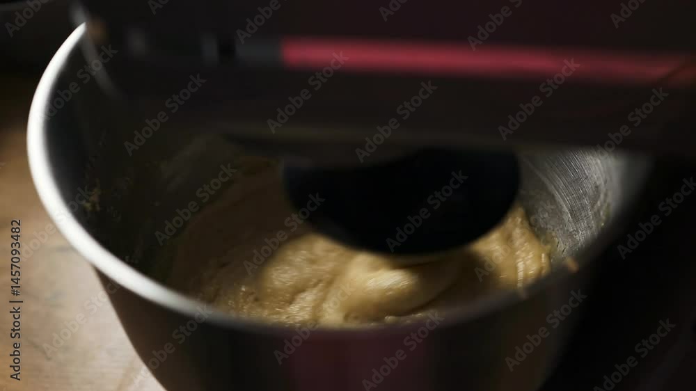 Close-up of an electric mixer blending batter or cream in a stainless steel bowl. A classic step in baking preparation, ideal for food tutorials, recipes, cooking blogs, and slow-living content. Close-up of an electric mixer blending batter or cream in a stainless steel bowl. A classic step in baking preparation, ideal for food tutorials, recipes, cooking blogs, and slow-living content.