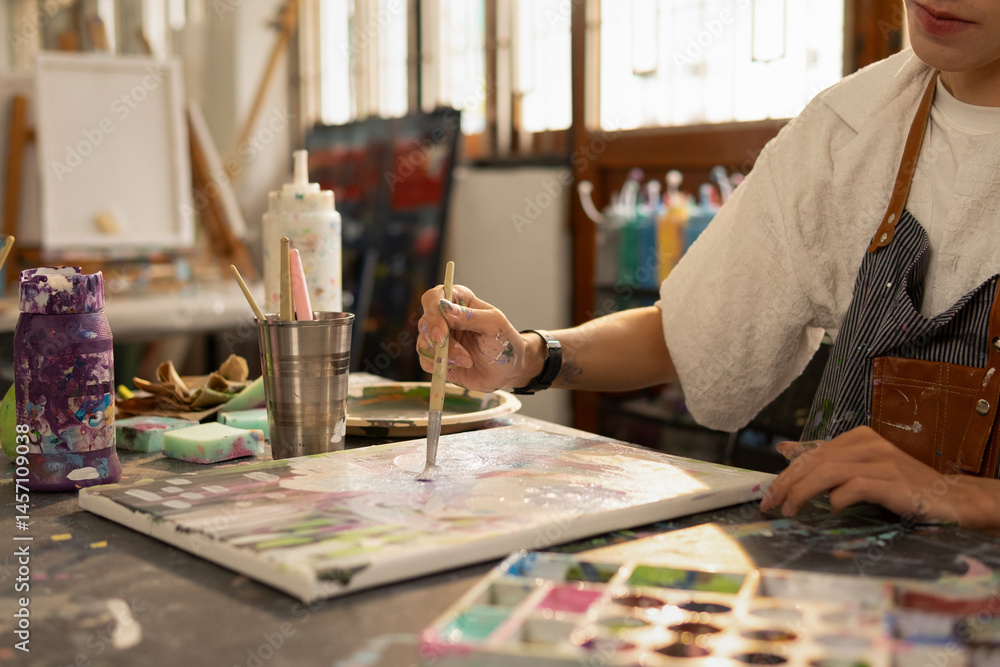 The artist paints with a brush. He creates modern masterpieces. Close-up. The artist paints with a brush. He creates modern masterpieces. Close-up.