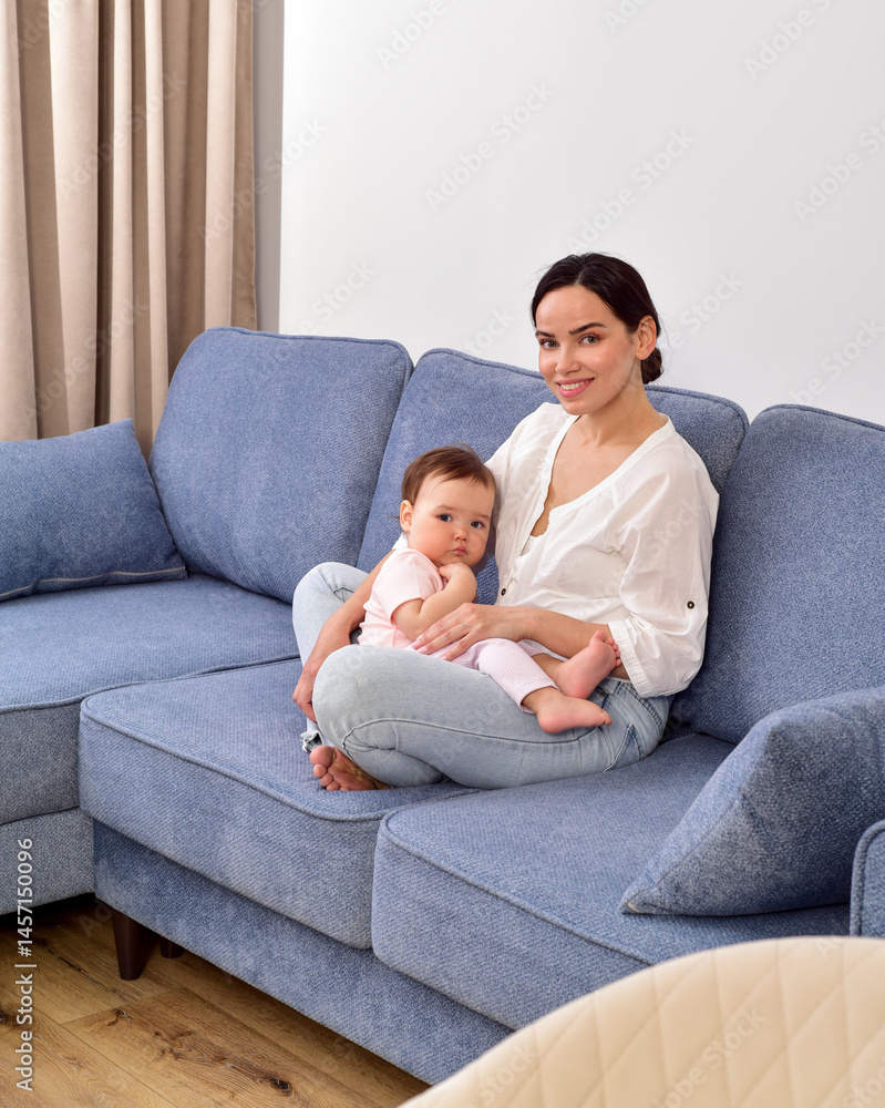 Mother and baby playing and smiling on the sofa. Happy family.Home interior. Mother and baby playing and smiling on the sofa. Happy family.Home interior.
