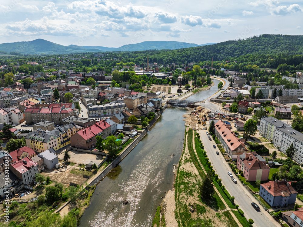 Naklejka premium Aerial drone view of Glucholazy, a city in Poland located in the Opole province. View of the rebuilt Glucholazy after the flood in spring 2025. View on the white Gluchoaska river.