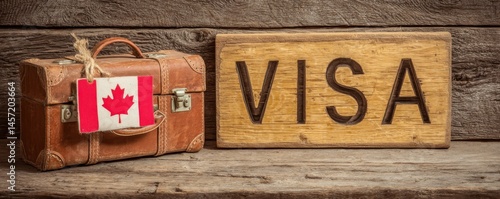 Vintage suitcase with Canadian flag next to a wooden visa sign.