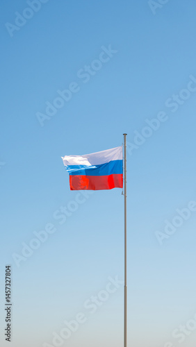 Obraz na płótnie Large flag of the Russian Federation on a flagpole against a blue sky. Close up w salonie