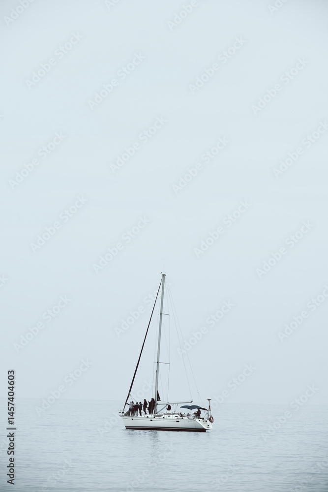 Tranquil sea journey with sailboat on calm waters under clear sky Tranquil sea journey with sailboat on calm waters under clear sky