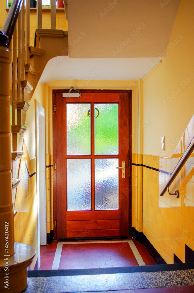 Wooden Door with Frosted Glass Panels at the Bottom of a Staircase Landing Inside a Residential Building