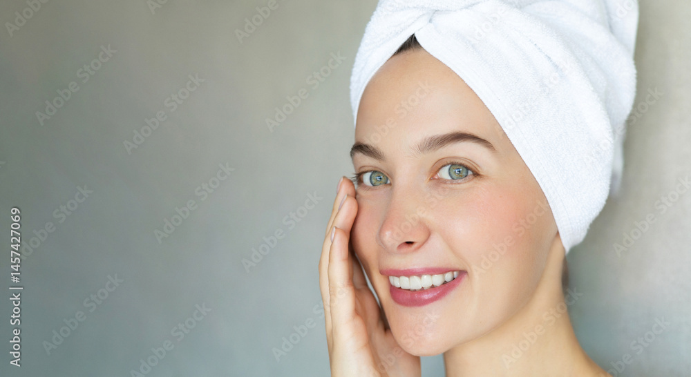 Glowing young woman with bright green eyes and a soft smile enjoying her skincare routine, wrapped in a white towel. Her flawless skin radiates freshness against the calm neutral background. Glowing young woman with bright green eyes and a soft smile enjoying her skincare routine, wrapped in a white towel. Her flawless skin radiates freshness against the calm neutral background.