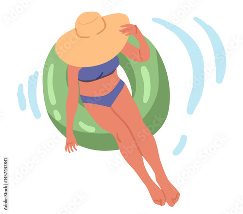 Woman wearing swimsuit and trendy summer hat swimming in inflatable rubber ring overhead view