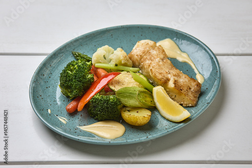 Obraz na płótnie Grilled White Fish with Steamed Vegetables and Lemon w salonie