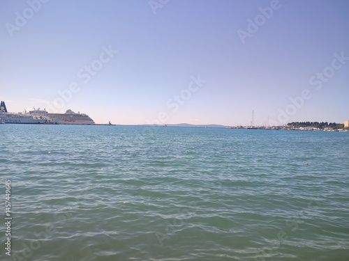 Calm Seaside Horizon with Distant Shoreline and Clear Blue Sky