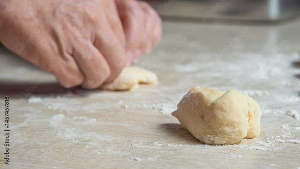 Raw homemade bread, preparing and kneading the bread before baking, on a wooden surface, selective focus. Raw homemade bread, preparing and kneading the bread before baking, on a wooden surface, selective focus.