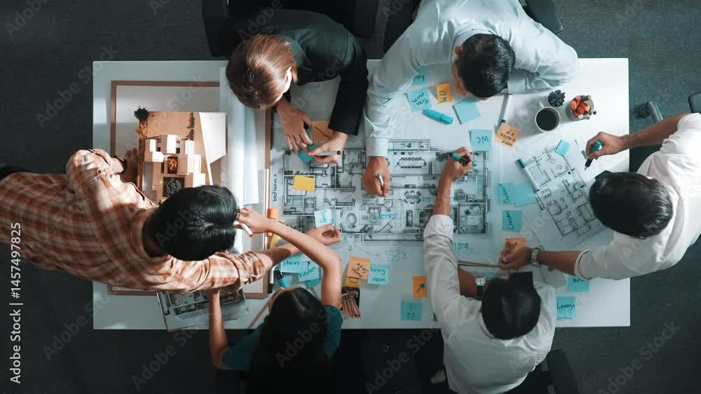 Top aerial view of project manager or civil engineer writing at blueprint and planning building design. Aerial view of architect working together at meeting table with document placed. Alimentation.
