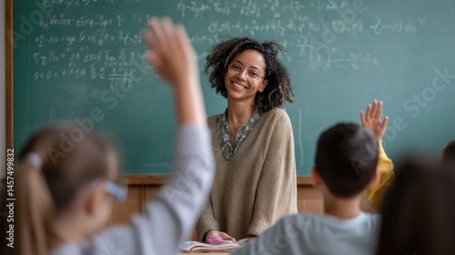 Obraz na płótnie A teacher at a chalkboard enthusiastically writing equations while students raise their hands to participate highlighting an interactive math lesson. w salonie