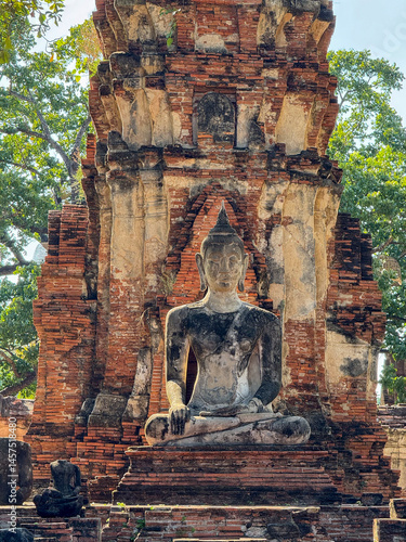 Serene Buddha statues outdoors at the old Thai temple landmark, Wat Maha That tourism. Ancient historical brick structures symbolizing peace and spirituality, famous Buddhist culture.