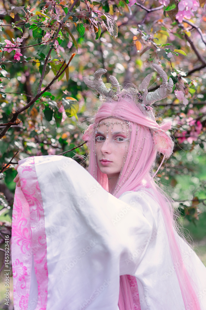 Deer dryad girl against the background of a blooming pink apple tree