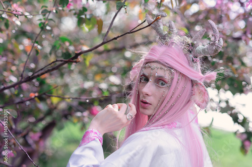 Obraz na płótnie Deer dryad girl against the background of a blooming pink apple tree w salonie
