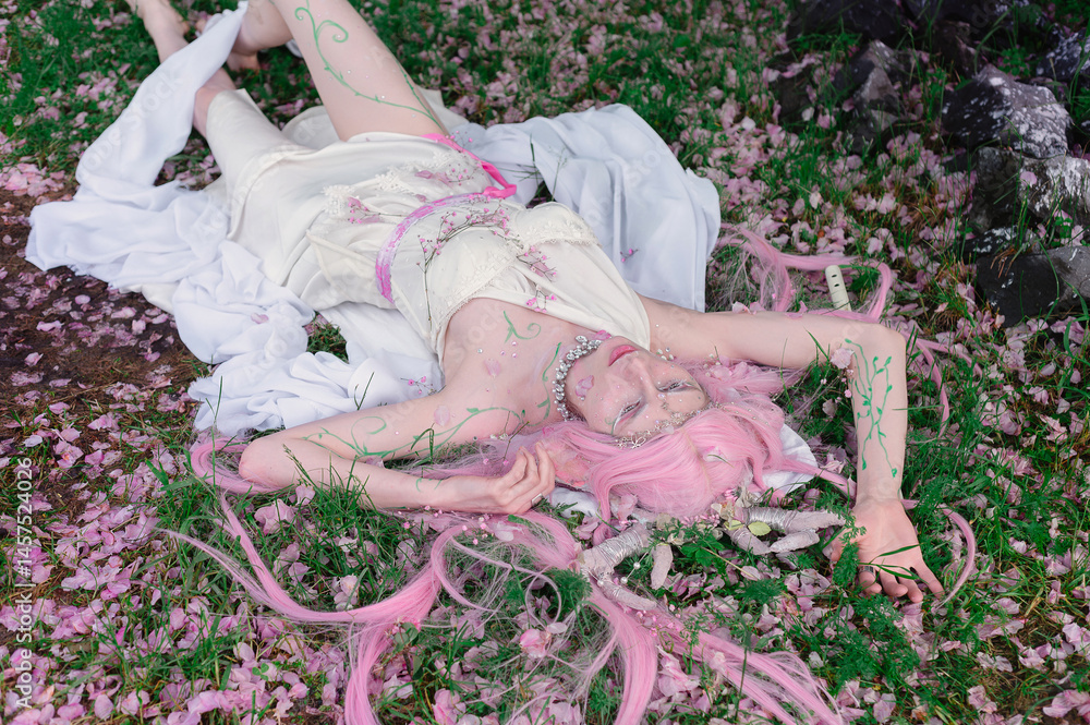 Deer dryad girl against the background of a blooming pink apple tree