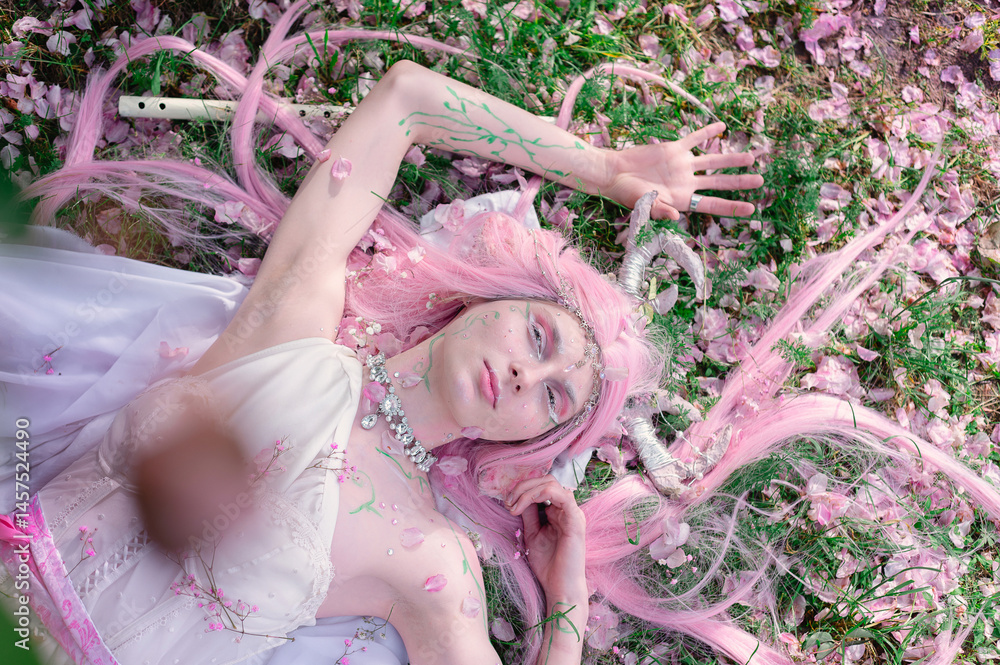 Deer dryad girl against the background of a blooming pink apple tree