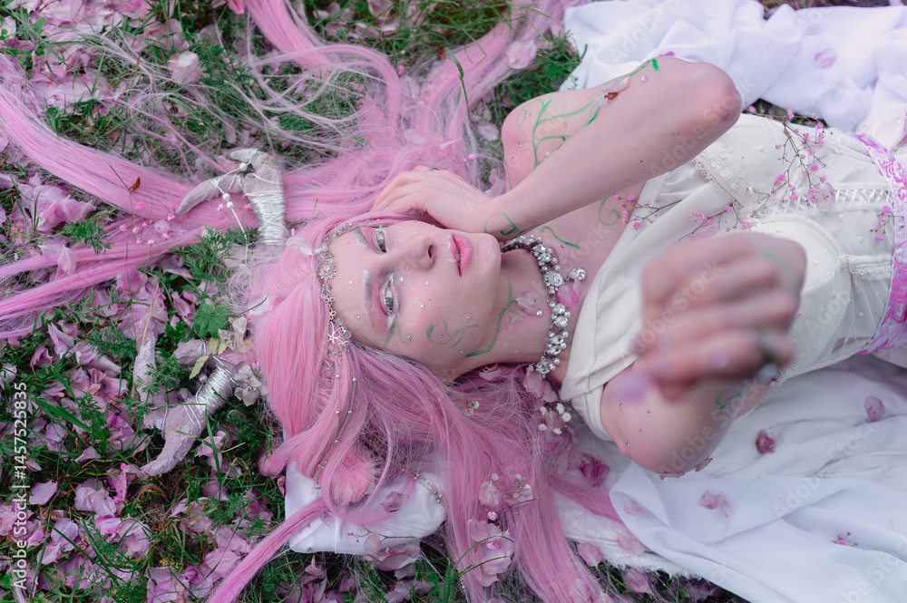 Deer dryad girl against the background of a blooming pink apple tree