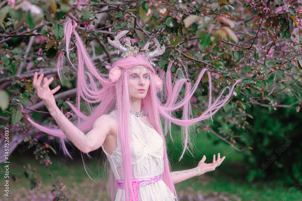 Deer dryad girl against the background of a blooming pink apple tree