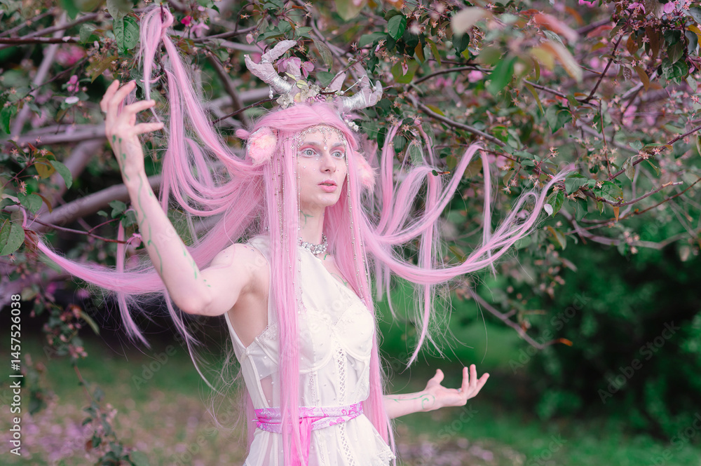 Deer dryad girl against the background of a blooming pink apple tree