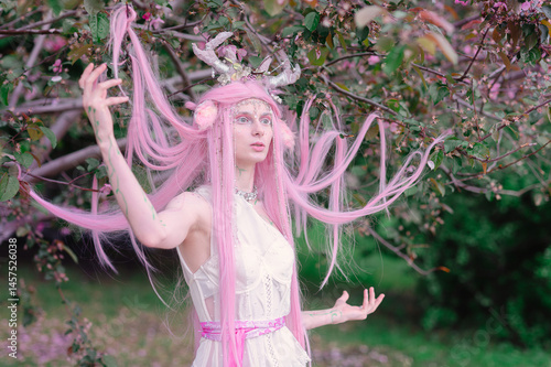 Obraz na płótnie Deer dryad girl against the background of a blooming pink apple tree w salonie