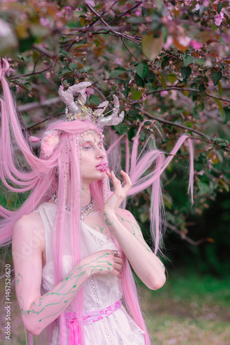 Obraz na płótnie Deer dryad girl against the background of a blooming pink apple tree w salonie