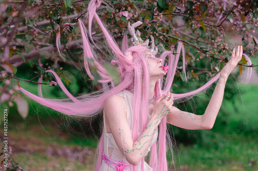Deer dryad girl against the background of a blooming pink apple tree