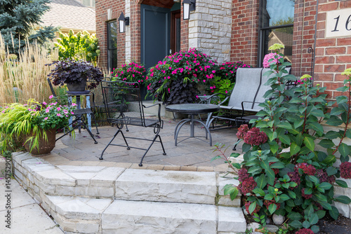 Beautiful Little Lime hydrangea bushes and Karl Foerster feather reed  grasses in full bloom late summer lend a romantic feel and curb appeal to the front entrance of this suburban residence. 