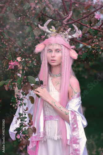 Obraz na płótnie Deer dryad girl against the background of a blooming pink apple tree w salonie