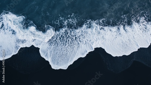 Obraz na płótnie Aerial perspective of waves crashing onto a black basaltic sand beach w salonie