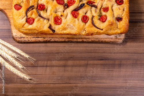 Traditional Italian Focaccia with cherry tomatoes, black olives and rosemary.