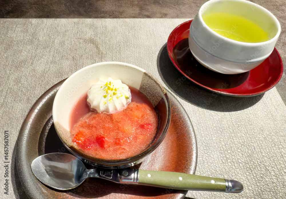 Japanese bowl of strawberry and cream dessert with green tea drink on table