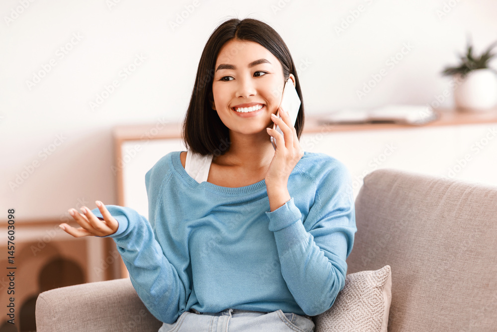 Phone Call. Portrait of smiling asian lady talking on cellphone, resting on couch in living room at home. Communication Concept. Cheerful woman having pleasant conversation, sharing news with friend Phone Call. Portrait of smiling asian lady talking on cellphone, resting on couch in living room at home. Communication Concept. Cheerful woman having pleasant conversation, sharing news with friend
