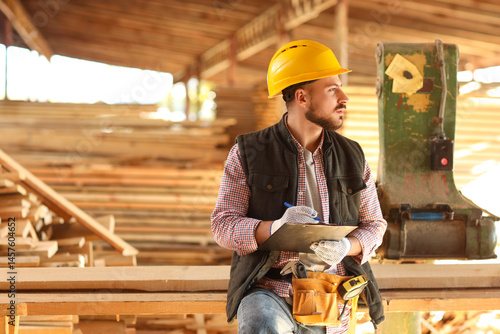 Young carpenter in hardhat ...