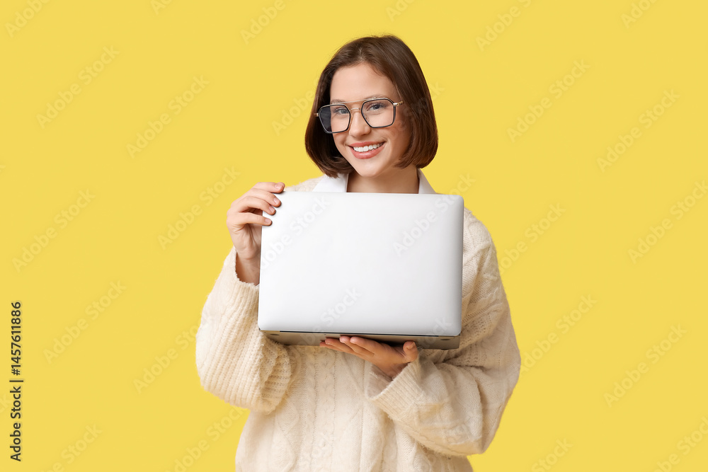 Happy young woman with modern laptop on yellow background Happy young woman with modern laptop on yellow background