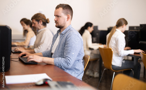 Young man working on computer with team in coworking space