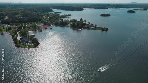 Pleasure boat passes shore and beautiful estates of Lake Norman