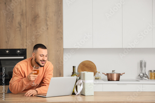 Young man drinking wine and...