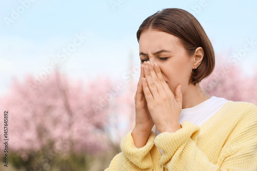 Allergic young woman sneezi...