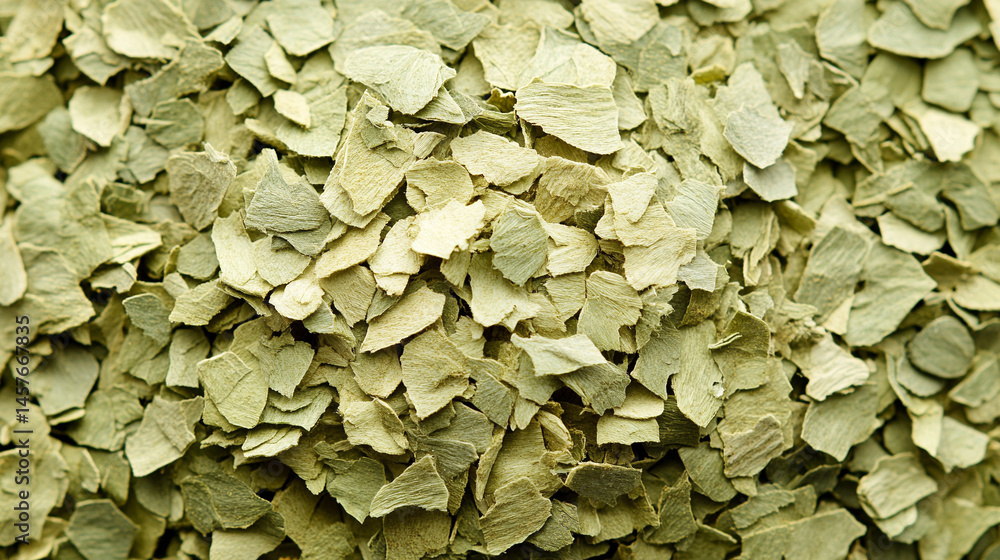 Top view of a textured pile of dried and chopped basil spice, symbolizing natural flavor, culinary tradition, and the essence of Mediterranean cooking in organic, earthy tones.