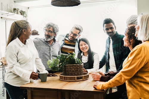Happy group of people have fun drinking coffee together. Friends of different skin and age in office break time