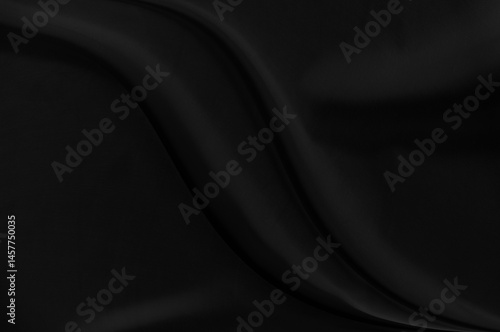 Black gray satin dark fabric texture luxurious shiny that is abstract silk cloth background with patterns soft waves blur beautiful.