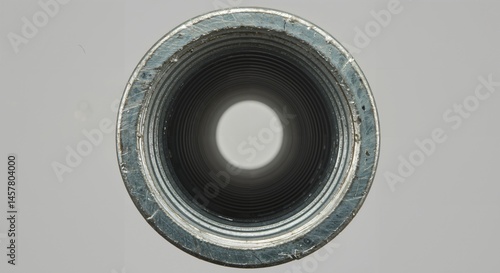Metal pipe internal screw threads and circular opening viewed looking down the bore in close-up.