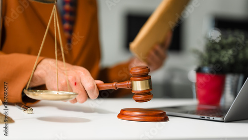 Obraz na płótnie An elderly Caucasian male lawyer works at his desk in a law firm, offering legal advice and business law services. A gavel and documents symbolize justice and professionalism w salonie