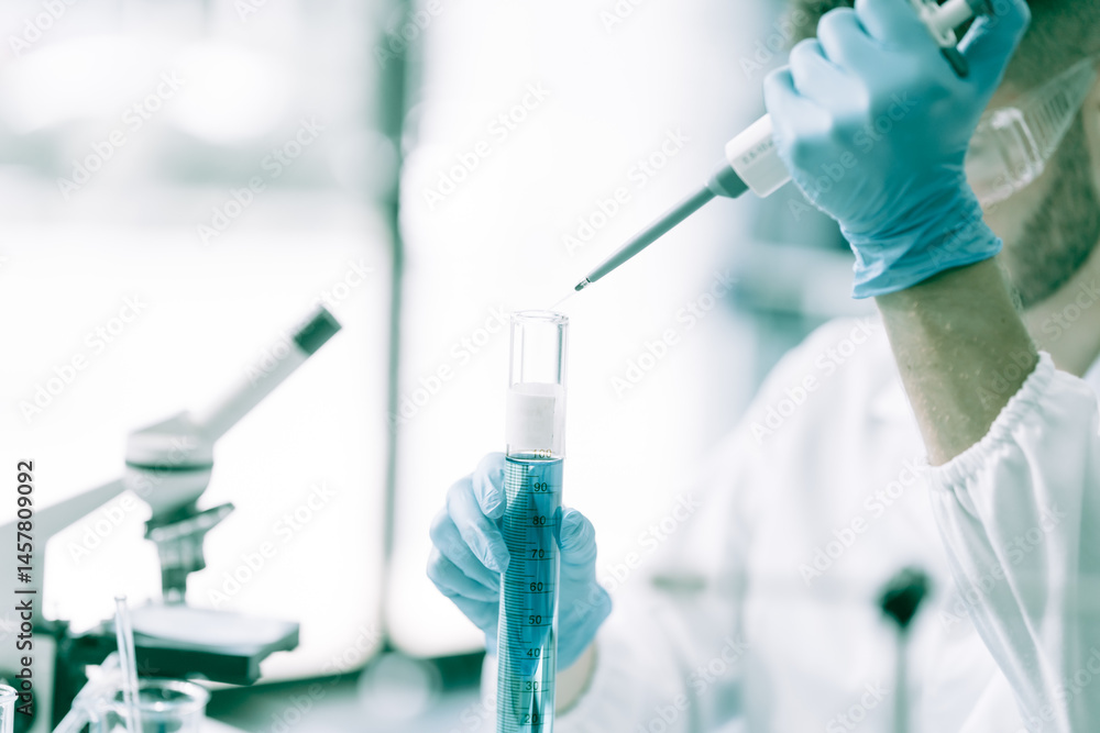 A white male scientist at a table, studying blue substances in test tubes and bottles, using a microscope for chemical research in pharmaceuticals, analyzing compounds for medical advancements