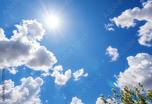 Fototapeta Naklejka Na Ścianę i Meble -  Looking up at a vibrant spring sky, fluffy white clouds scattered across brilliant blue, sun shining brightly, nature, majestic