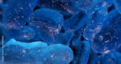 Extreme detailed view of geometric copper sulfate crystals forming in laboratory glassware under bright lighting
