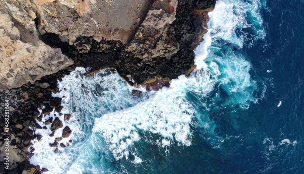 Obraz premium Dynamic ocean waves crash against rugged cliffs coastal landscape aerial view natural beauty serenity