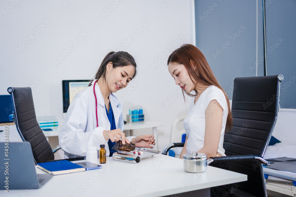 An Asian woman sits at a table consulting with a female doctor. They discuss her symptoms related to stress and depression. The doctor listens attentively and recommends treatment and medication An Asian woman sits at a table consulting with a female doctor. They discuss her symptoms related to stress and depression. The doctor listens attentively and recommends treatment and medication